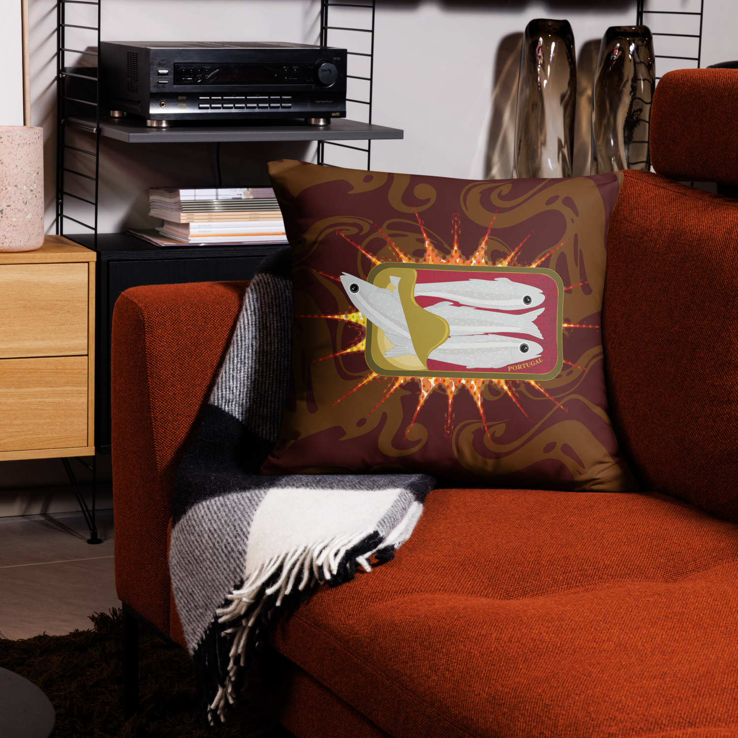 Decorative pillow featuring a sardine can design on a patterned background, displayed on an orange sofa.