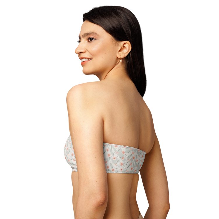 Woman wearing a floral-patterned strapless bandeau top.