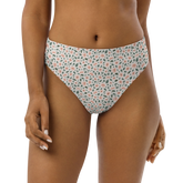 Woman wearing white bikini bottom with pink floral pattern.