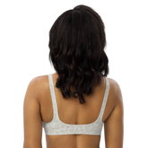 Woman wearing a white floral-patterned sports bra from the back.