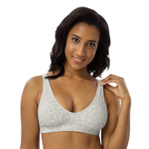 Woman wearing a white sports bra with green floral pattern.