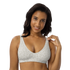 Woman wearing a white sports bra with green floral pattern.