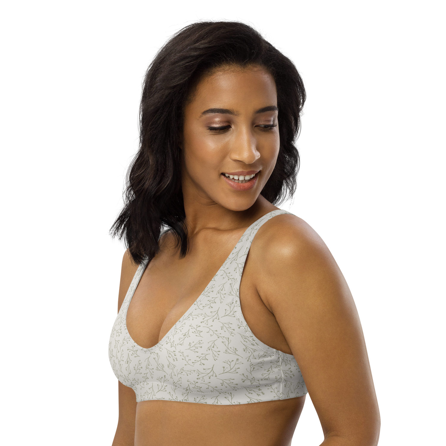 Woman wearing a white sports bra with a delicate green leaf pattern.