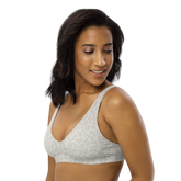Woman wearing a white sports bra with a delicate green leaf pattern.