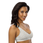 Woman wearing a white sports bra with a delicate green leaf pattern.