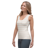 Woman wearing a white tank top with thin orange stripes and gray leggings.